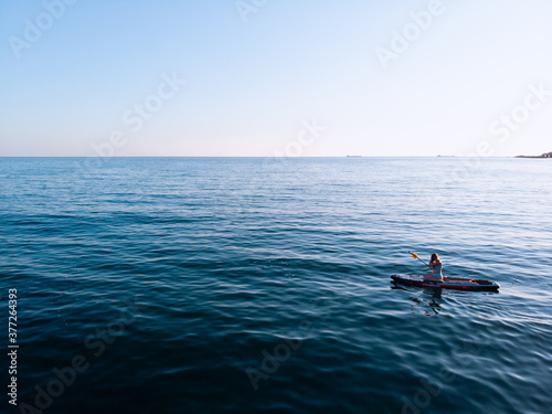 Attractive Woman on Stand Up Paddle Board, Woman paddling on sup board and enjoying turquoise transparent water. Tropical travel, wanderlust and water activity concept. Sunset and relax © Air_Lady
