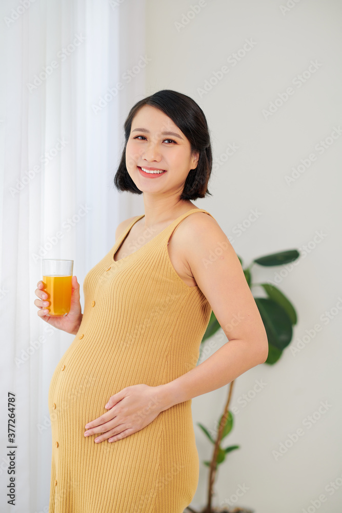 Beautiful pregnant woman is holding juice at home. Beautiful pregnant woman is holding juice at home.