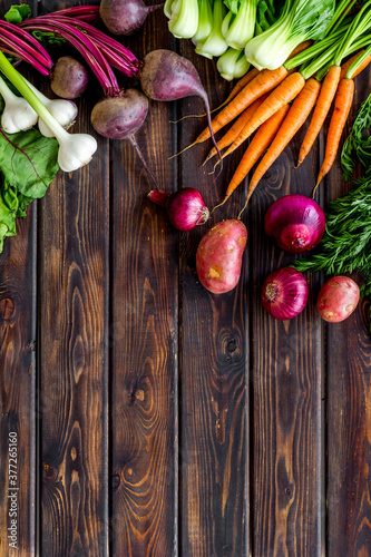 Flat lay of fresh vegetables and greenery on wooden table top-down copy space