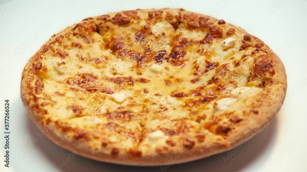 Selective focus of pizza with cheese spinning on white background Selective focus of pizza with cheese spinning on white background