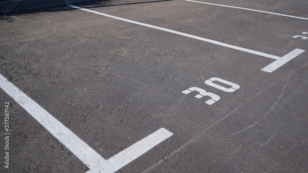 Close-up of a white paint number marking in a parking lot. Empty parking lot, Parking lot with white mark, Open parking in public park. Number 30.