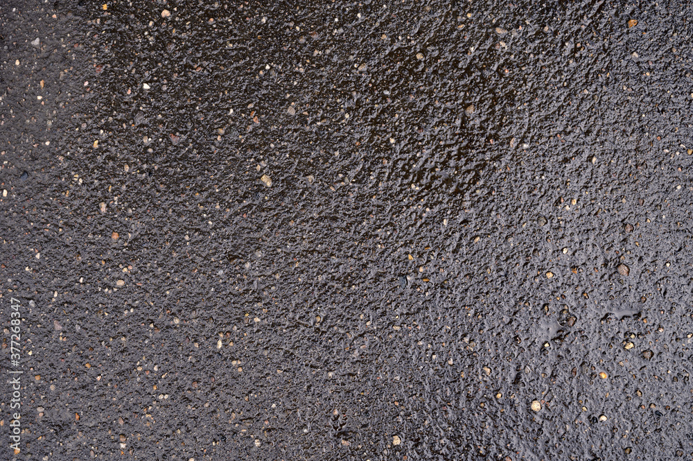 Abstract background of black wet asphalt with inclusions of pebbles Abstract background of black wet asphalt with inclusions of pebbles