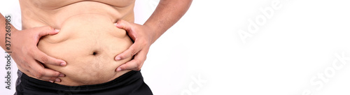 Close up of fatty Men's hand catching his fat belly  or Man's hand grabbing his fat on white background in studio With copy space.