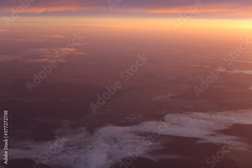 Sonnenaufgang oder Sonnenuntergang über den Wolke aus dem Flugzeug fotografiert, der Himmel oist blutrot und schön. Landschaft von oben