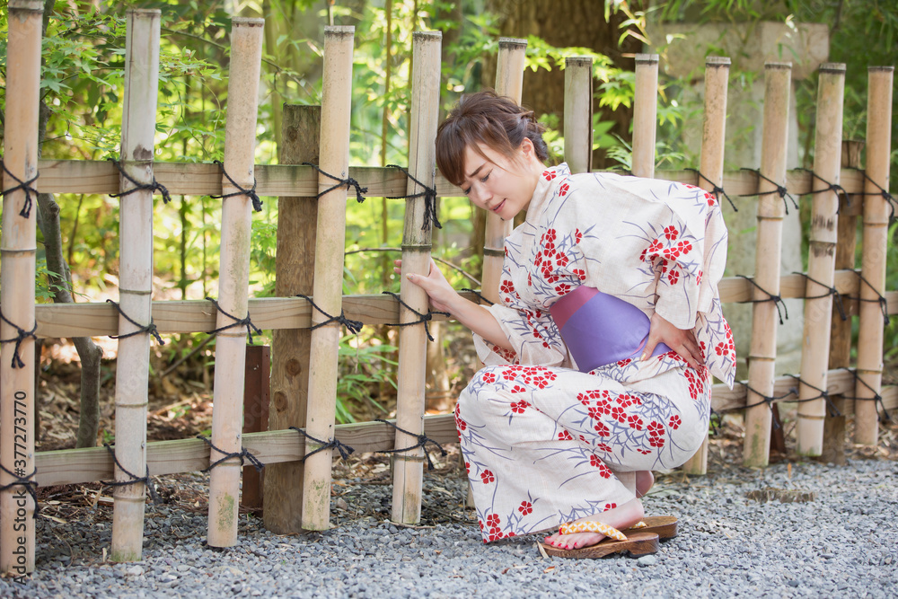 浴衣をきた腰痛の女性 Stock Photo | Adobe Stock