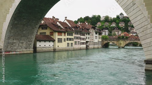 Aare river passing under Untertorbrucke bridge and old town houses on the shoreline in Bern Switzerland photo