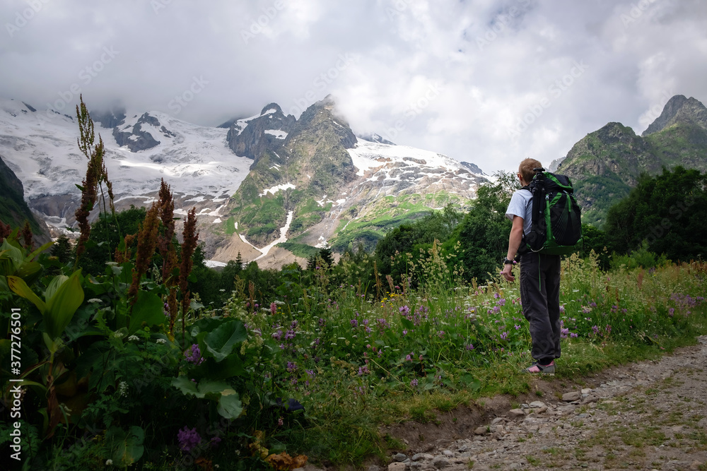 Man with backpack hiking in mountains. Travel Lifestyle success concept