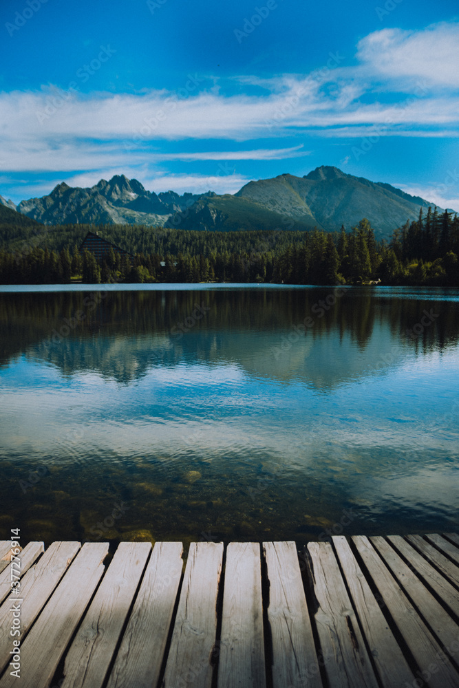 wooden pier on lake with mountains
