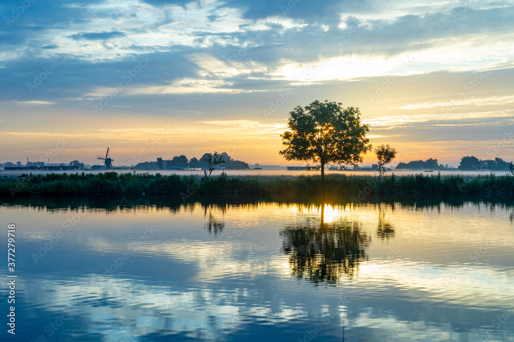 Obraz premium Sunrise over the meadows of the Zwanburgerpolder at the Kagerplassen in the South-Holland village of Warmond in the Netherlands.