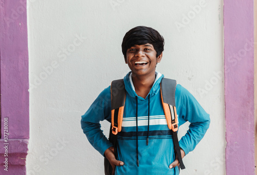 Portrait of an Indian school kid smiling with arms crossed in front of the camera