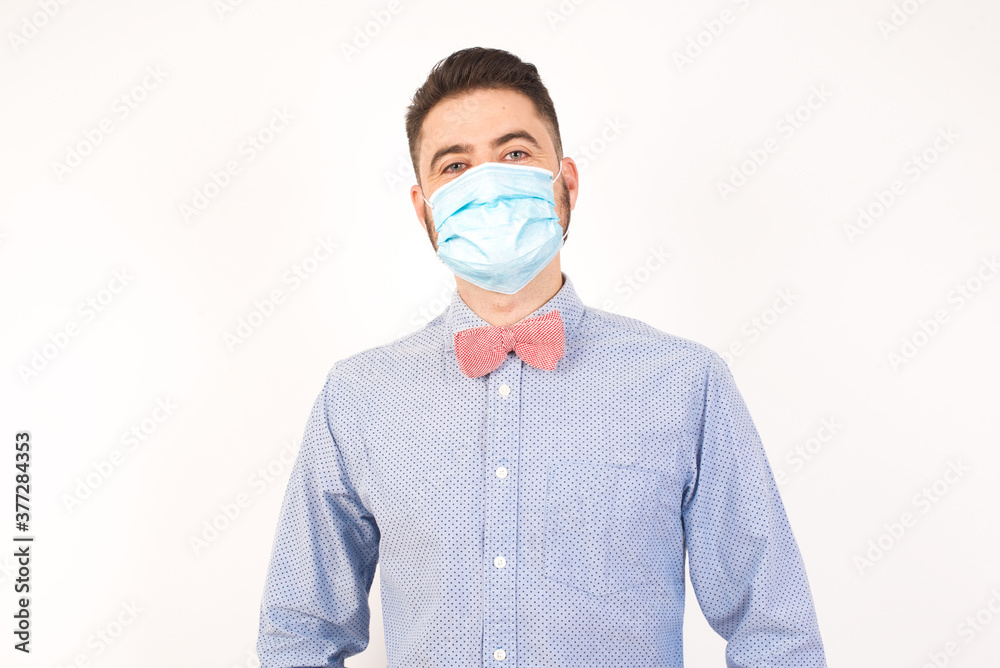 Confidence and business concept. Portrait of charming successful young man, smiling broadly with self-assured expression while holding hands in pockets standing against gray wall. Confidence and business concept. Portrait of charming successful young man, smiling broadly with self-assured expression while holding hands in pockets standing against gray wall.