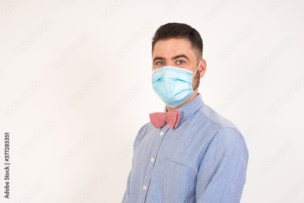 Shy blond boy smiling looking to the camera. Caucasian charming young man sanding against studio background feeling shy. Shy blond boy smiling looking to the camera. Caucasian charming young man sanding against studio background feeling shy.
