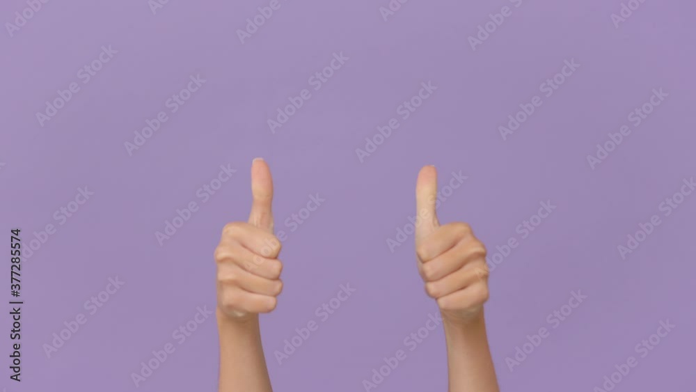 Close up cropped woman hand pointing fingers on you to camera say cool approval showing thumbs up gesture like sign isolated on purple violet background in studio. Advertising area workspace mock up