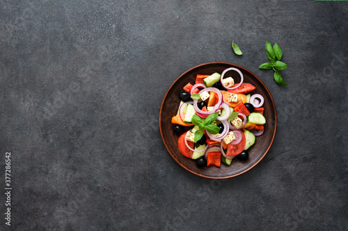 Greek salad with feta and olives on a black concrete background. View from above.
