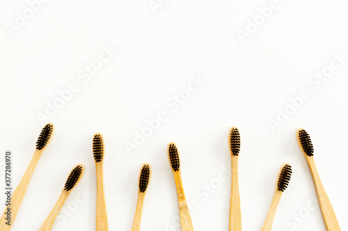 Eco materials concept with bamboo tooth brush on white background top view copy space