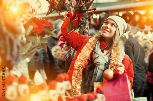 Young female near counter with xmas gifts on street market. High quality photo © JackF
