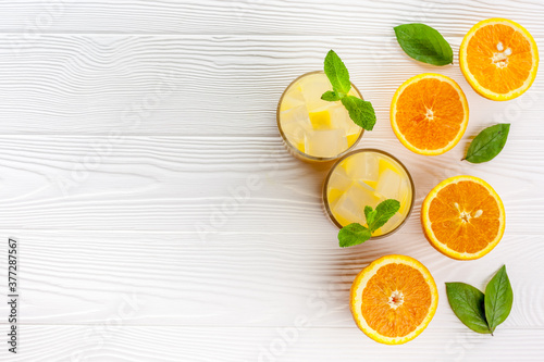 Summer drink from orange with ice on white wooden background top view flat lay copy space