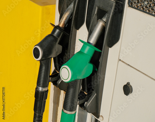Two green and black gas pump nozzles at gas station close-up. Gas industry. Energy. Gas/diesel, benzine, petroleum station business.