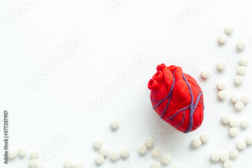 Heart and treatment. Heart near pills on white background top view