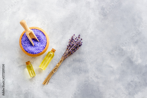 Lavender spa set. Violet bath salt, essence oil on grey stone background