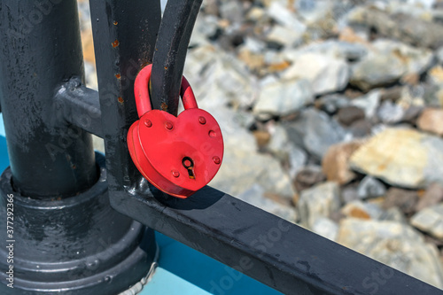 A padlock attached to the railing of the bridge as a symbol of a strong family marriage