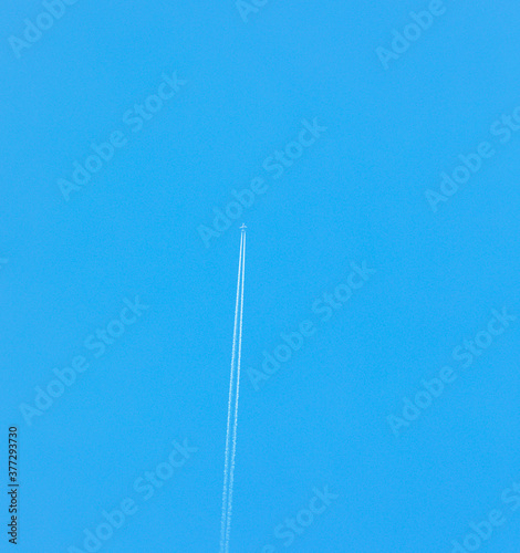 Airplane on clear blue sky. Flight trace in sky. For wallpaper, background and postcard.