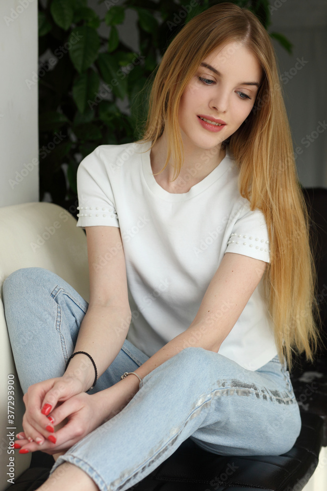 Blonde woman sitting on modern sofa Blonde woman sitting on modern sofa