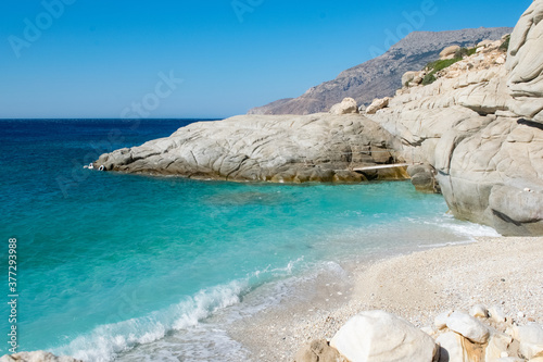 Seychelles beach in Ikaria with blue water and small waves on the shore