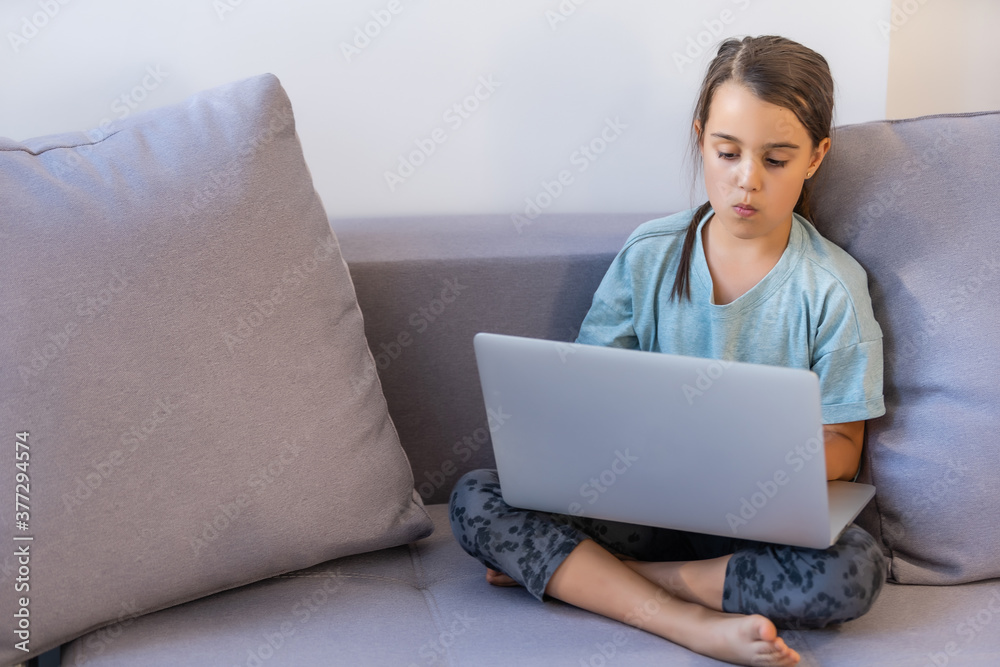 Cute little girl using laptop at home. Education, online study, home studying, distance learning, schoolgirl children lifestyle concept Cute little girl using laptop at home. Education, online study, home studying, distance learning, schoolgirl children lifestyle concept