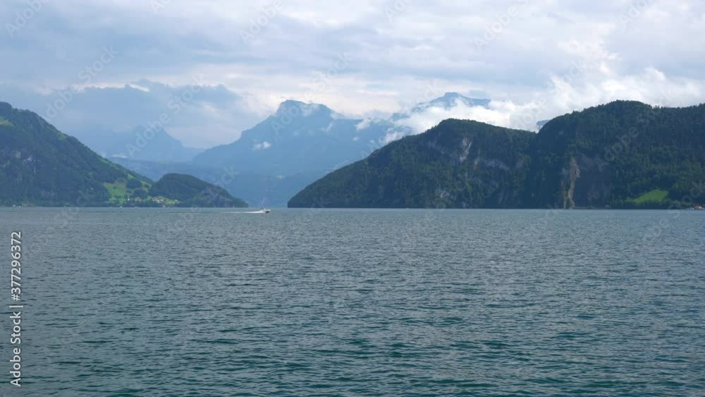 Panorama of Lake Lucerne with boat passing and mountains in background taken from a moving cruise boat in Switzerland Panorama of Lake Lucerne with boat passing and mountains in background taken from a moving cruise boat in Switzerland