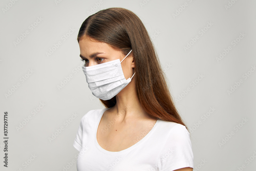 Portrait of a woman medical mask on the face looks to the side safety 