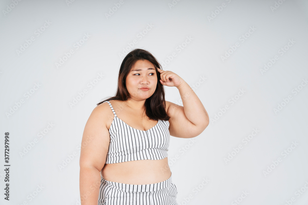 Thoughtful asian chubby woman pointing thinking of something. Thoughtful asian chubby woman pointing thinking of something.