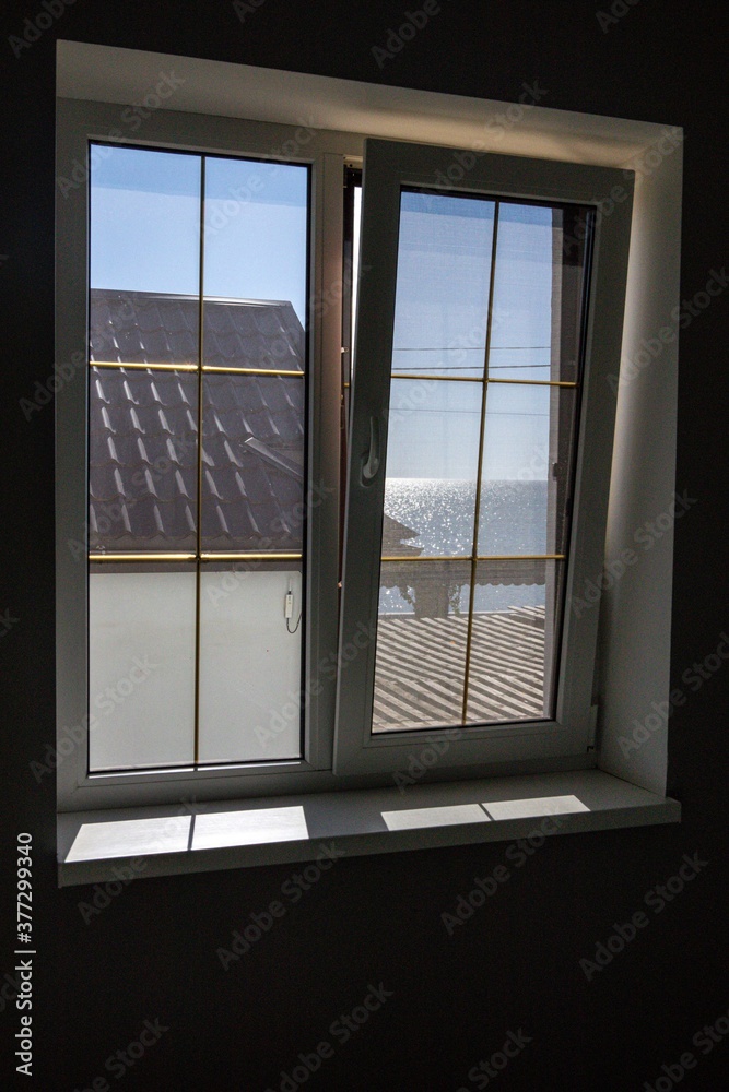 Fototapeta premium window overlooking the house and the sea. Excellent housing location