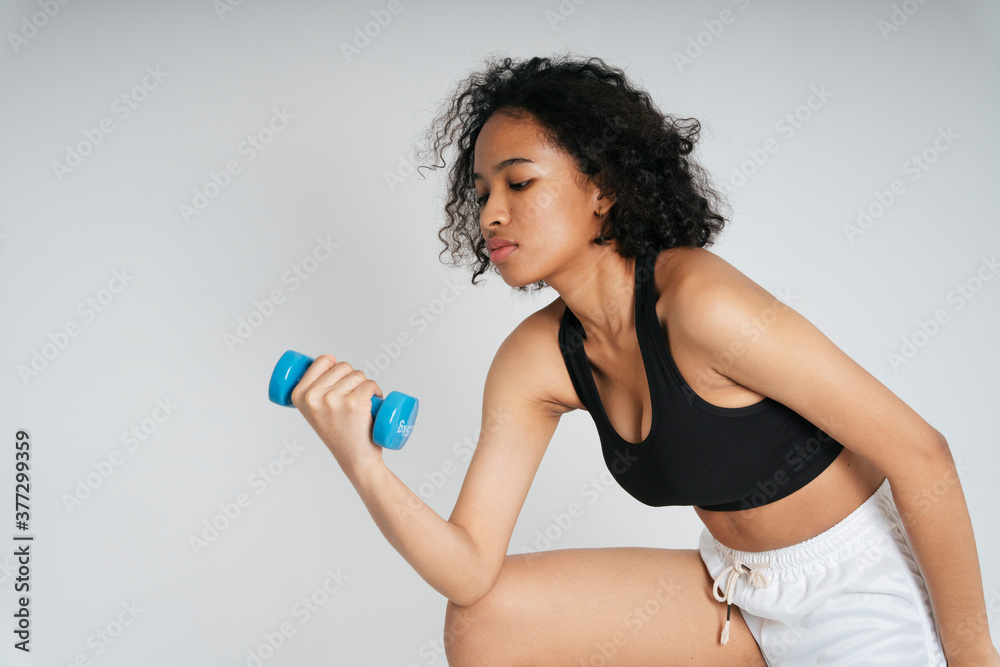 Mixed race african and thai woman exercise with blue dumbbell on white background. Mixed race african and thai woman exercise with blue dumbbell on white background.