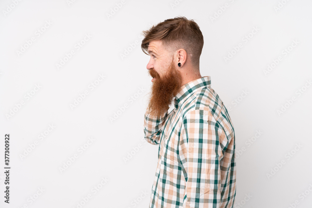 Redhead man with long beard over isolated white background keeping a conversation with the mobile phone with someone Redhead man with long beard over isolated white background keeping a conversation with the mobile phone with someone
