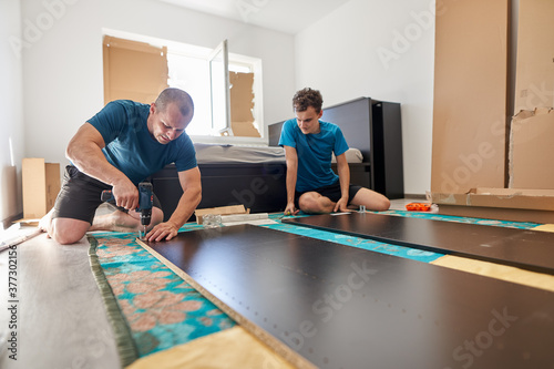 Father and son assembling furniture in new home