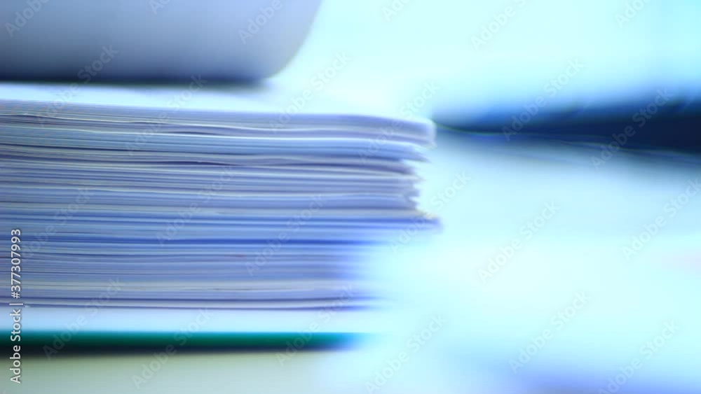 Close up of papers, stack of papers in the office. Slide the papers like a book.