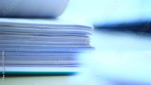 Close up of papers, stack of papers in the office. Slide the papers like a book.