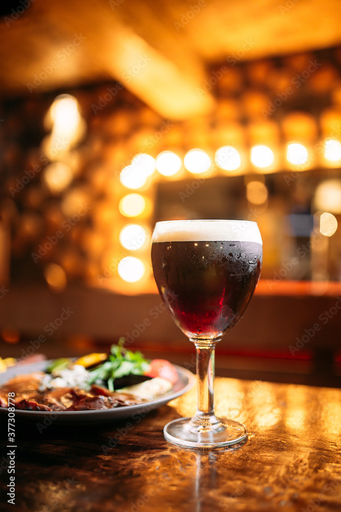 Meat and vegetables dish with a glass of dark beer