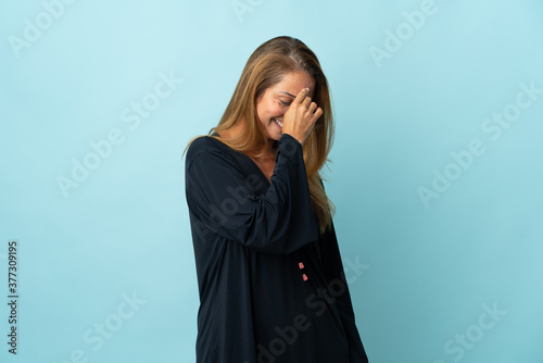 Middle age brazilian woman isolated on blue background laughing