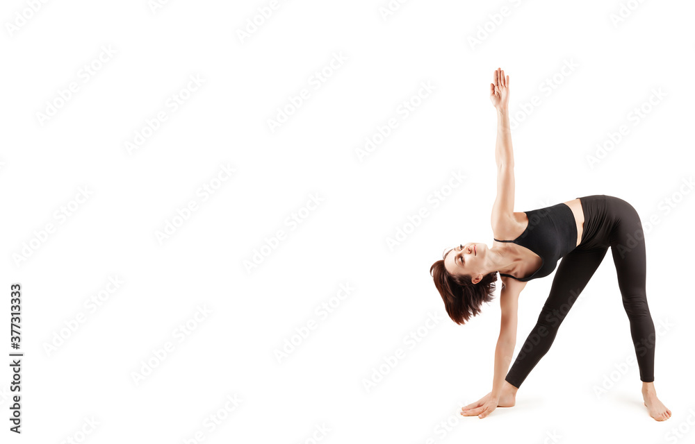 young beautiful woman in black leggings and top doing fitness indoors, on a white background, isolate young beautiful woman in black leggings and top doing fitness indoors, on a white background, isolate