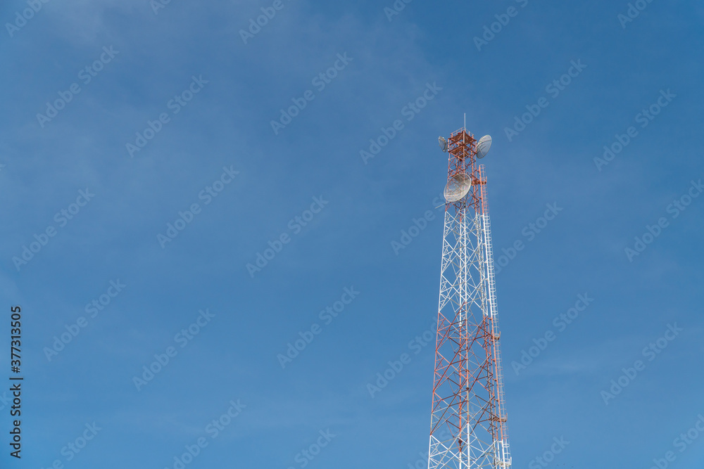Obraz premium Telecommunication tower with blue sky and cloud in background. Broadcast pole with copy space. Wireless communication technology.