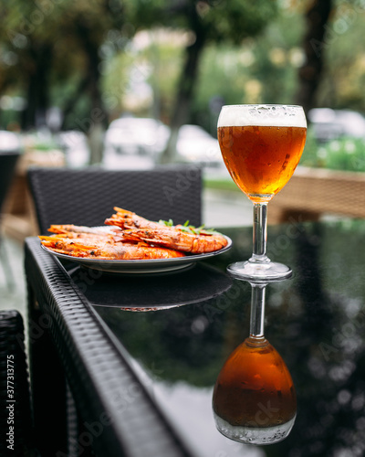 Golden beer in a glass with langoustines 
