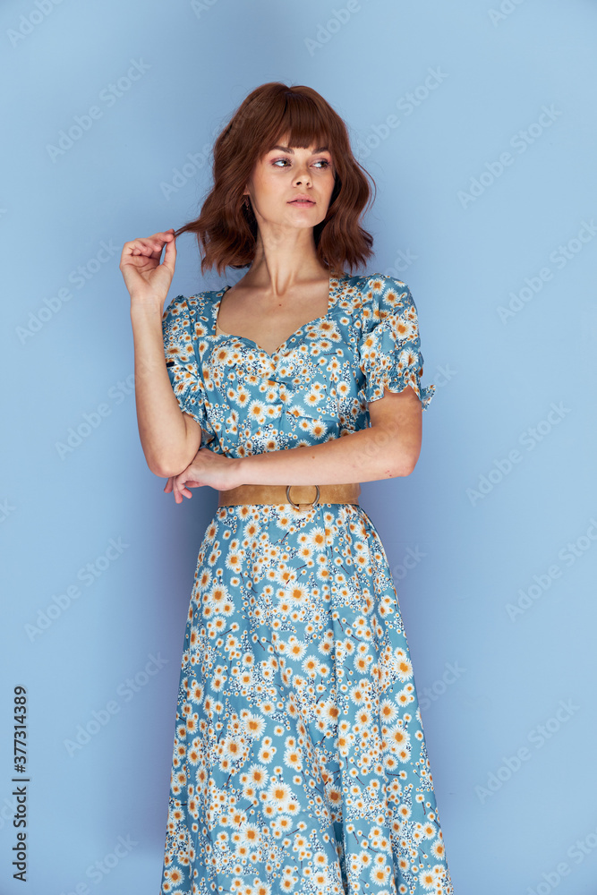 Woman in dress holding on to hair looking away 