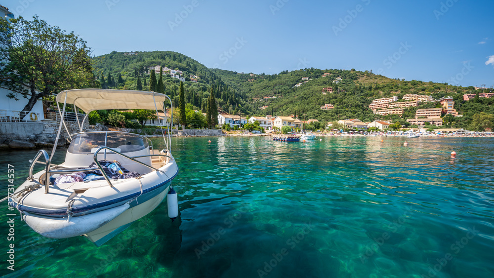 The clear waters of Kalami Bay, in Corfu, Greece, on a bright summers day