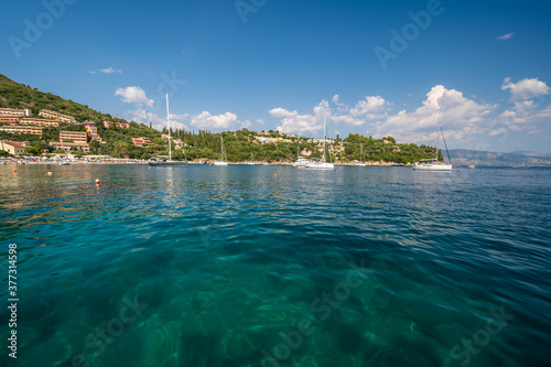 The clear waters of Kalami Bay, in Corfu, Greece, on a bright summers day photo