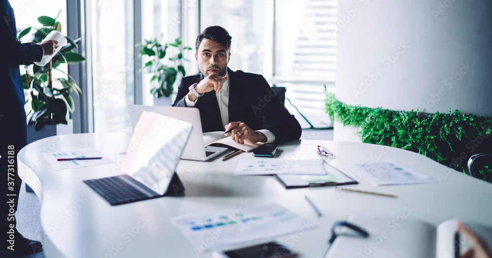 Serious successful businessman in formal suit working at desk in modern office Serious successful businessman in formal suit working at desk in modern office