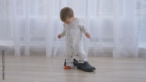 Little baby trying to wear daddy's big shoes