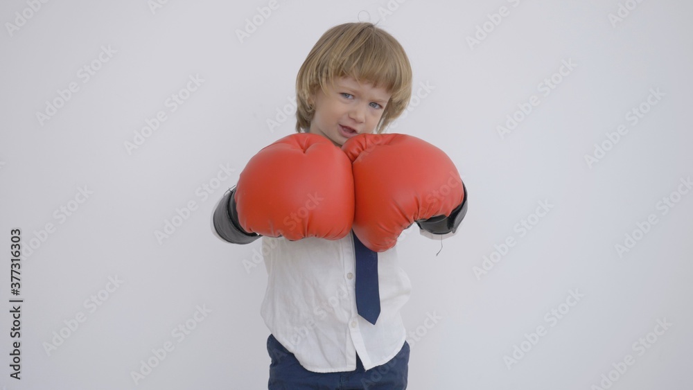 Funny boy playing the businessman with big red boxing gloves ready to fight Funny boy playing the businessman with big red boxing gloves ready to fight