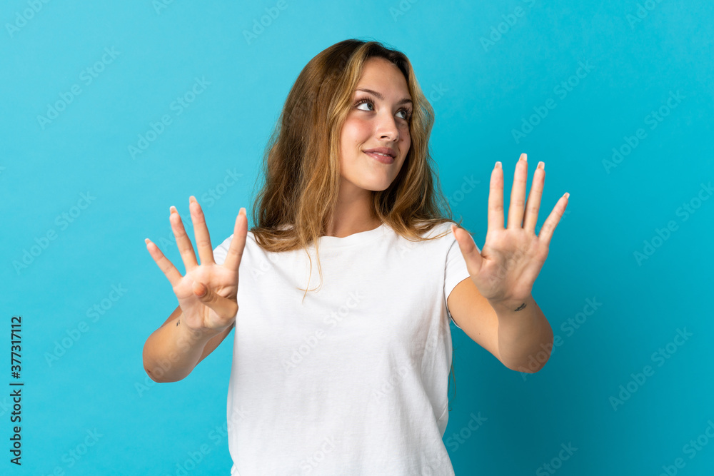 Young blonde woman isolated on blue background counting nine with fingers Young blonde woman isolated on blue background counting nine with fingers